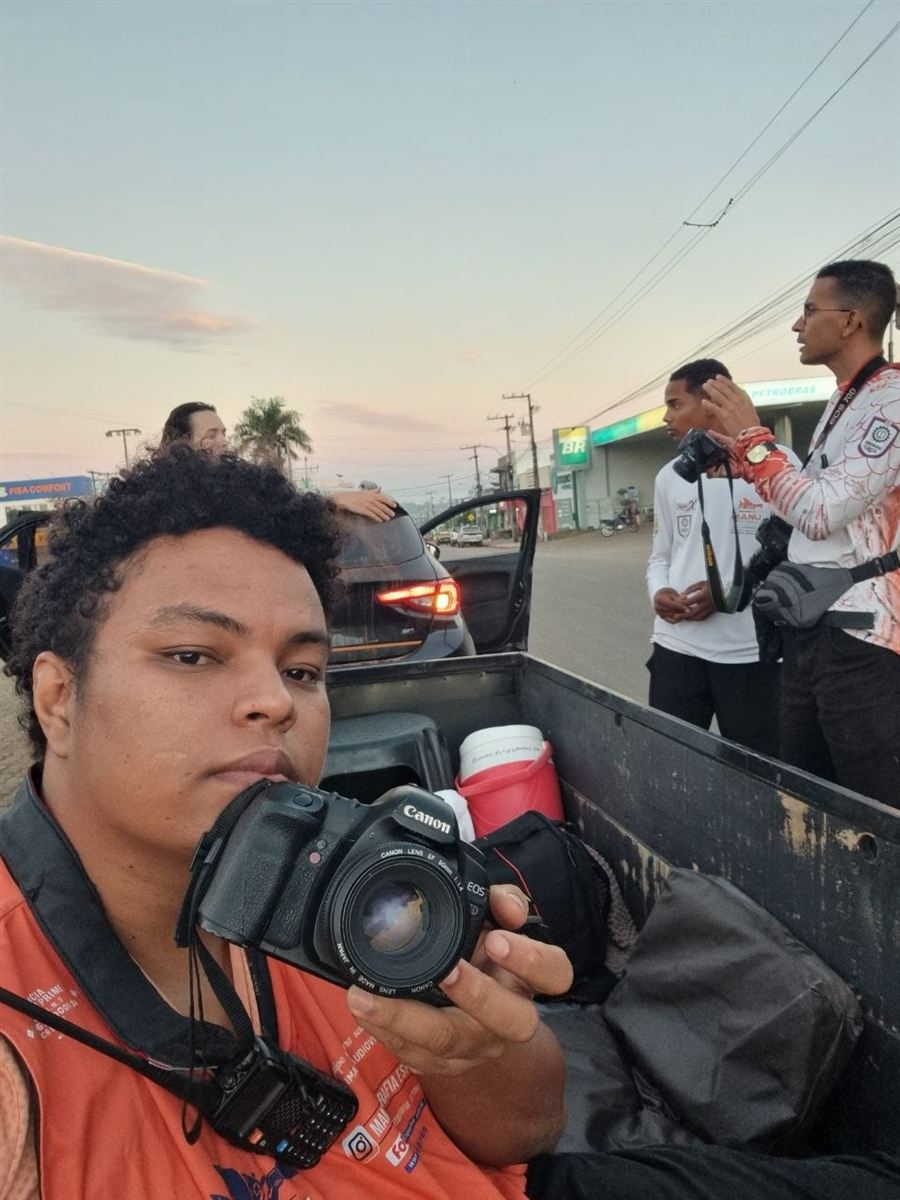 Bruno Mex com câmera fotográfica em um bastidor externo